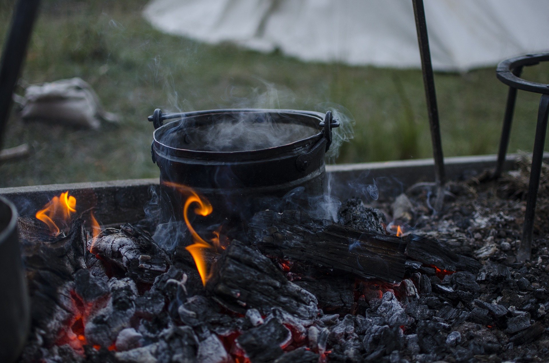 Ein gusseiserner Kessel steht auf einem Lagerfeuer